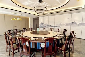 A conference room with a round table, chairs, and a large wall mural.