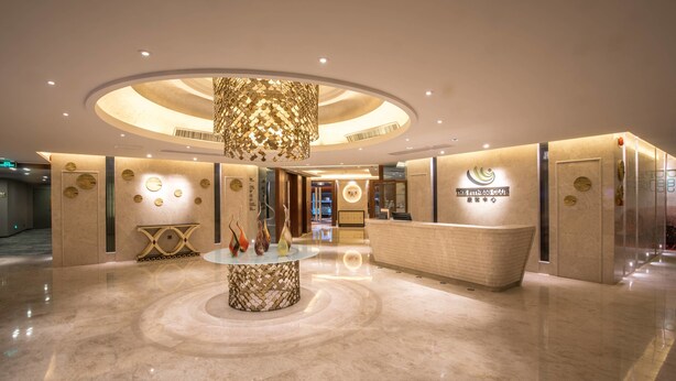 A hotel lobby with a reception desk, a decorative centerpiece, and a circular ceiling design. - Shantou International Hotel (Shantou)