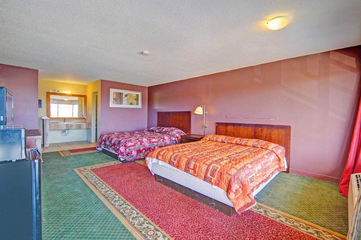 Une chambre d’hôtel avec deux lits, une salle de bain et un réfrigérateur.