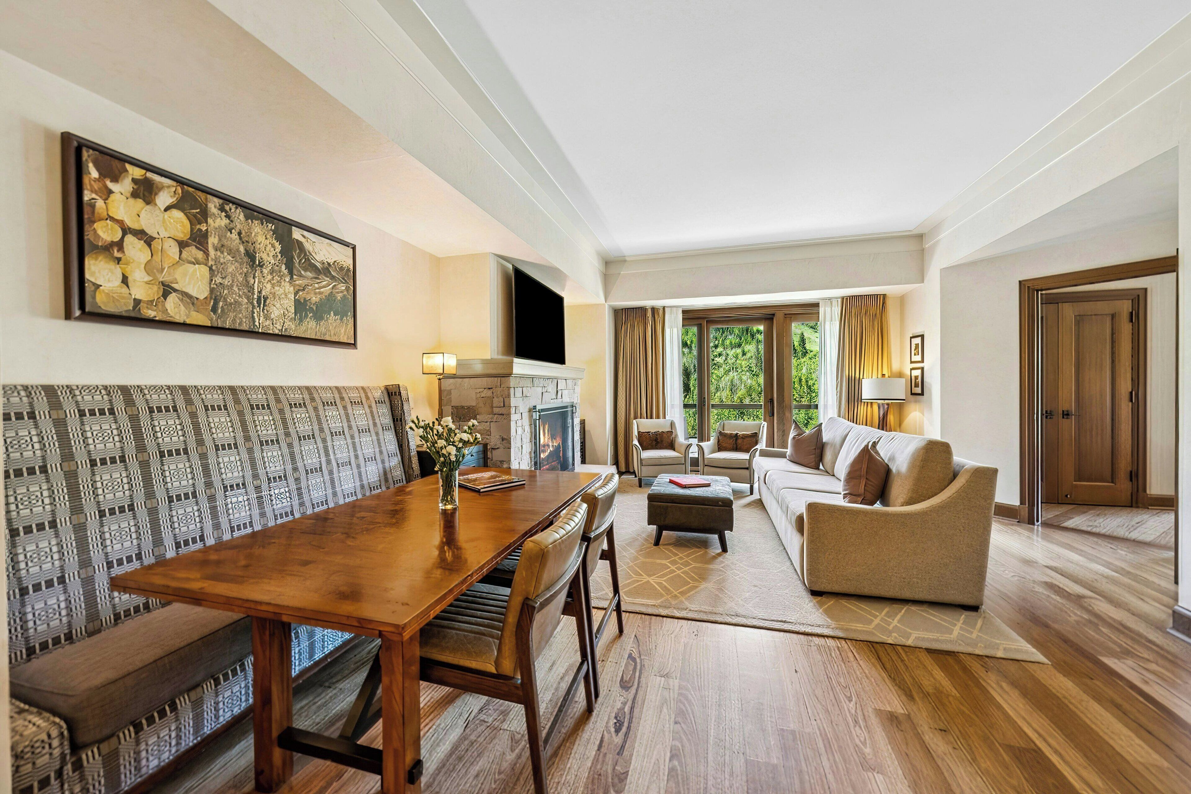 Amplia sala de estar con mesa de comedor de madera, sofá y chimenea.