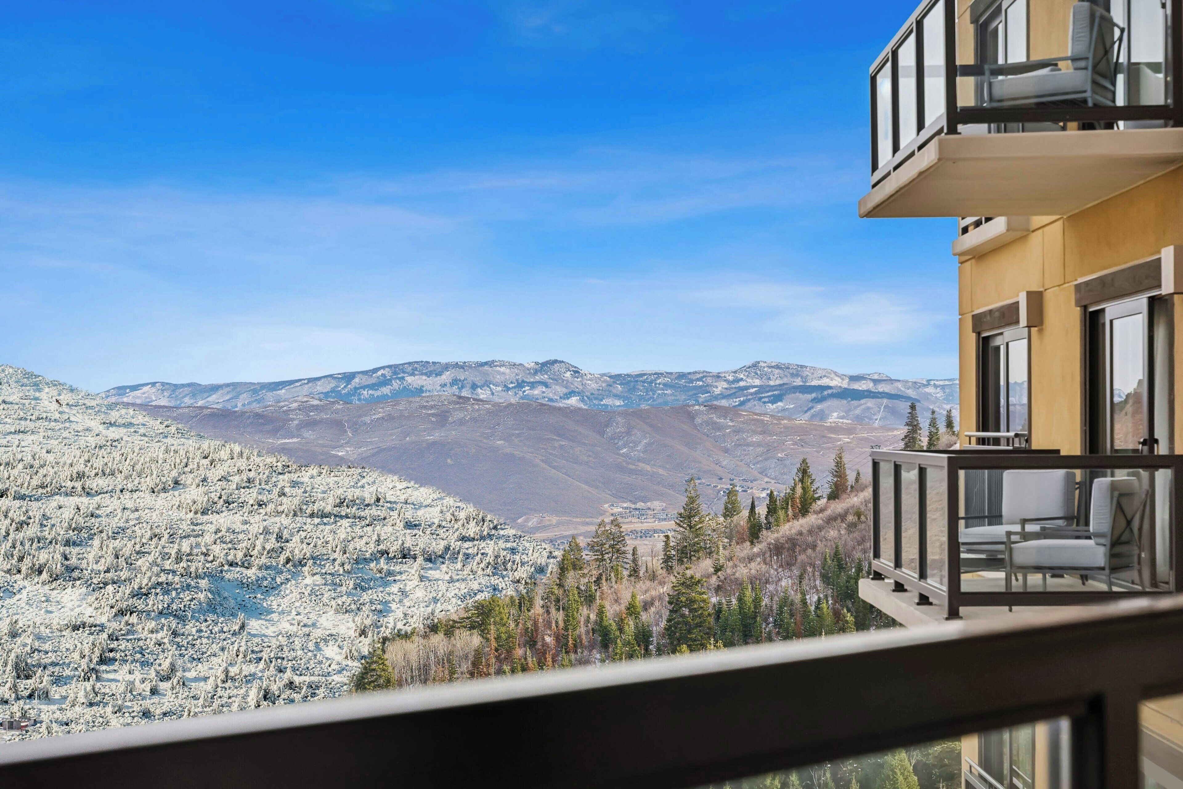 Un balcone con vista su montagne innevate e sullo skyline della città.