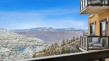 Un balcone con vista su montagne innevate e sullo skyline della città.