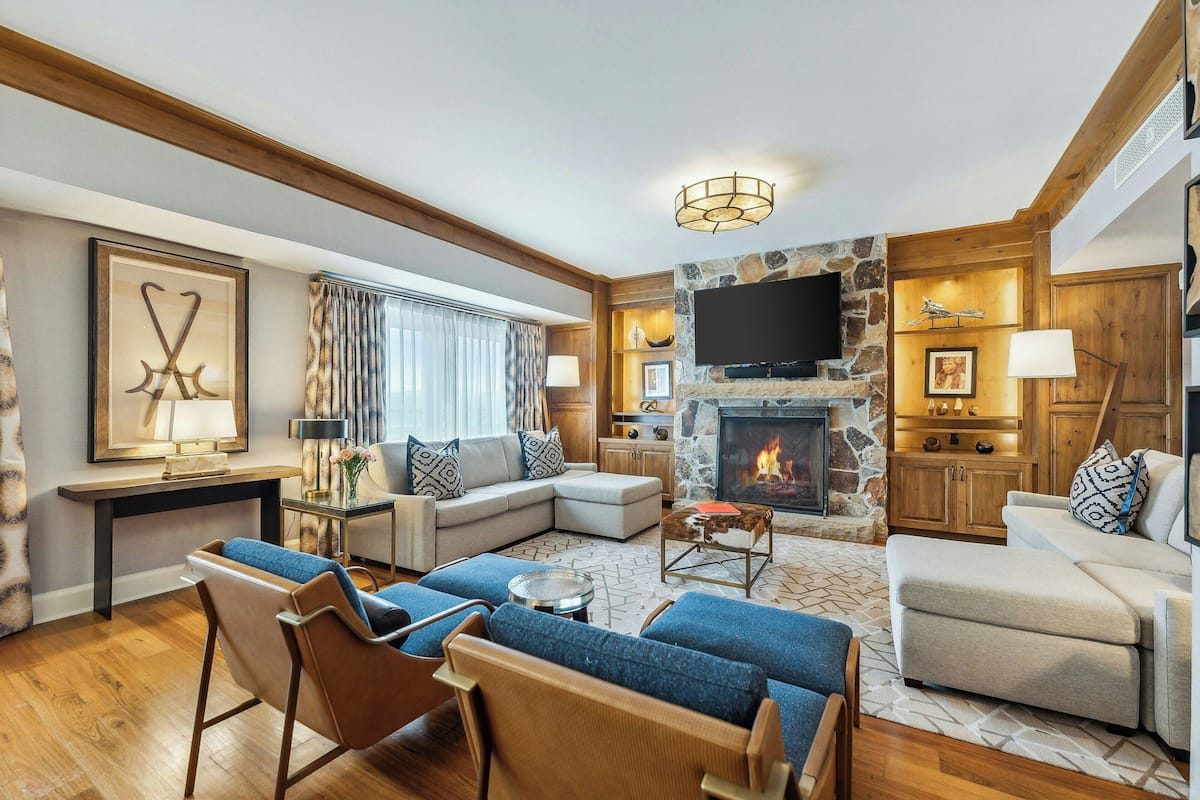 A cozy living room with a fireplace, comfortable seating, and a television.