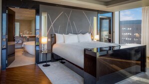 A modern hotel room with a large bed, a glass partition, a bathroom, and a city view. - Hilton Liverpool City Centre (Liverpool)