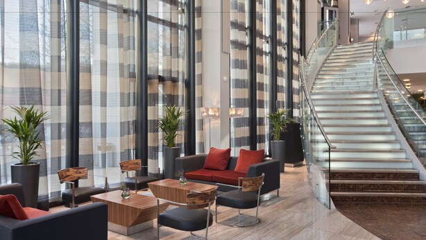 A spacious lobby with a modern staircase, comfortable seating, and large windows. - Hilton Liverpool City Centre (Liverpool)