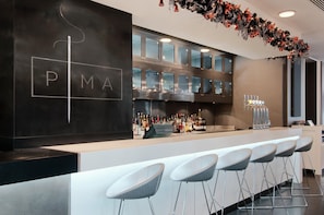A bar area with a counter, bar stools, and a decorative garland.