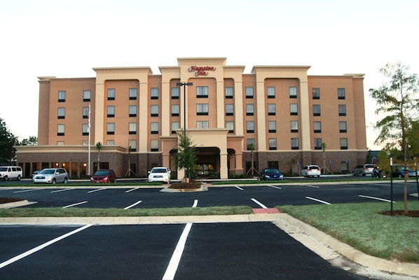 A Hampton Inn hotel with a parking lot in front.