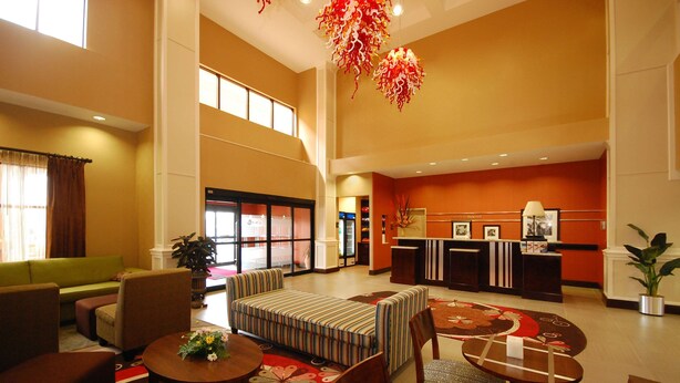 A spacious lobby with a reception desk, seating area, and large windows.