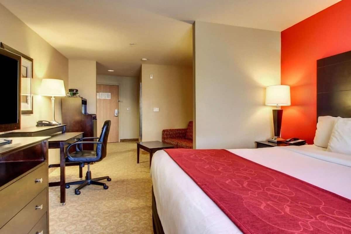 Ein Hotelzimmer mit Bett, Schreibtisch, Stuhl und Fernseher.