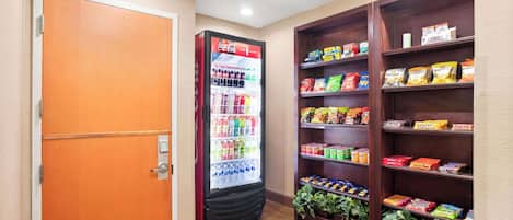 A vending machine with snacks and drinks, a closed door, and shelves with packaged goods.