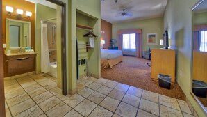 A hotel room with a bathroom, a bed, a desk, and a TV. - Holiday Inn Express Hotel Suites Lubbock Southwest-Wolfforth by IHG (Wolfforth)