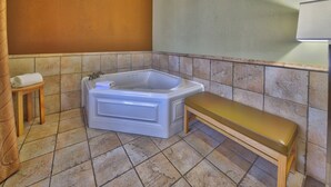 A bathroom with a bathtub, a bench, and a towel on a stool. - Holiday Inn Express Hotel Suites Lubbock Southwest-Wolfforth by IHG (Wolfforth)