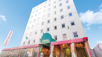Experience the modern design of Sakura Hotel & Cafe, featuring a striking grid of windows and a welcoming entrance.