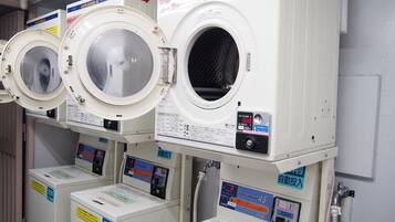 Een rij witte wasmachines met voorlader en bedieningspanelen, elk voorzien van Japanse tekst.