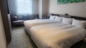 A hotel room with two beds, a sofa, a window with curtains, a painting on the wall, and a carpeted floor.