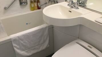 Un baño moderno con bañera, lavamanos e inodoro.