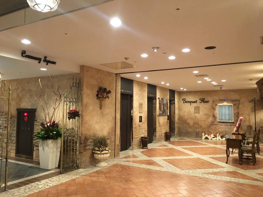 A spacious lobby with a tiled floor, a reception desk, and a sign indicating the Banquet Floor.