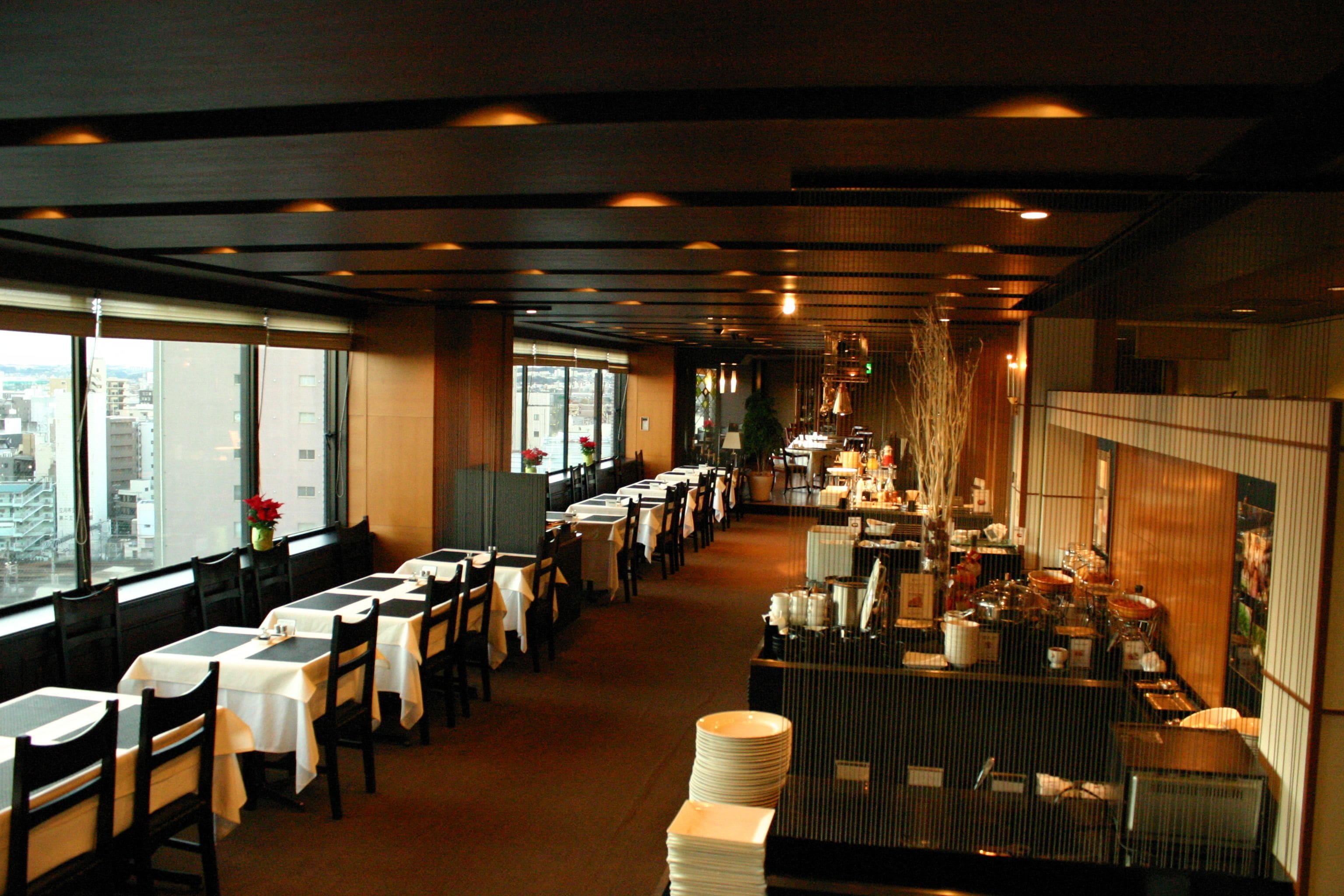 Un ristorante con lunghe tavolate, sedie e un'area buffet.