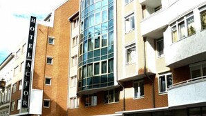 Ein mehrstöckiges Hotel mit einem großen, gut sichtbaren 'HOTEL'-Schild, großen Fenstern und einem modernen architektonischen Design.