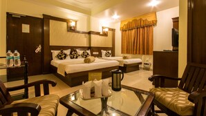 A hotel room with two beds, a glass table, a coffee pot, and a TV. - Hotel Grand Park Inn (New Delhi)