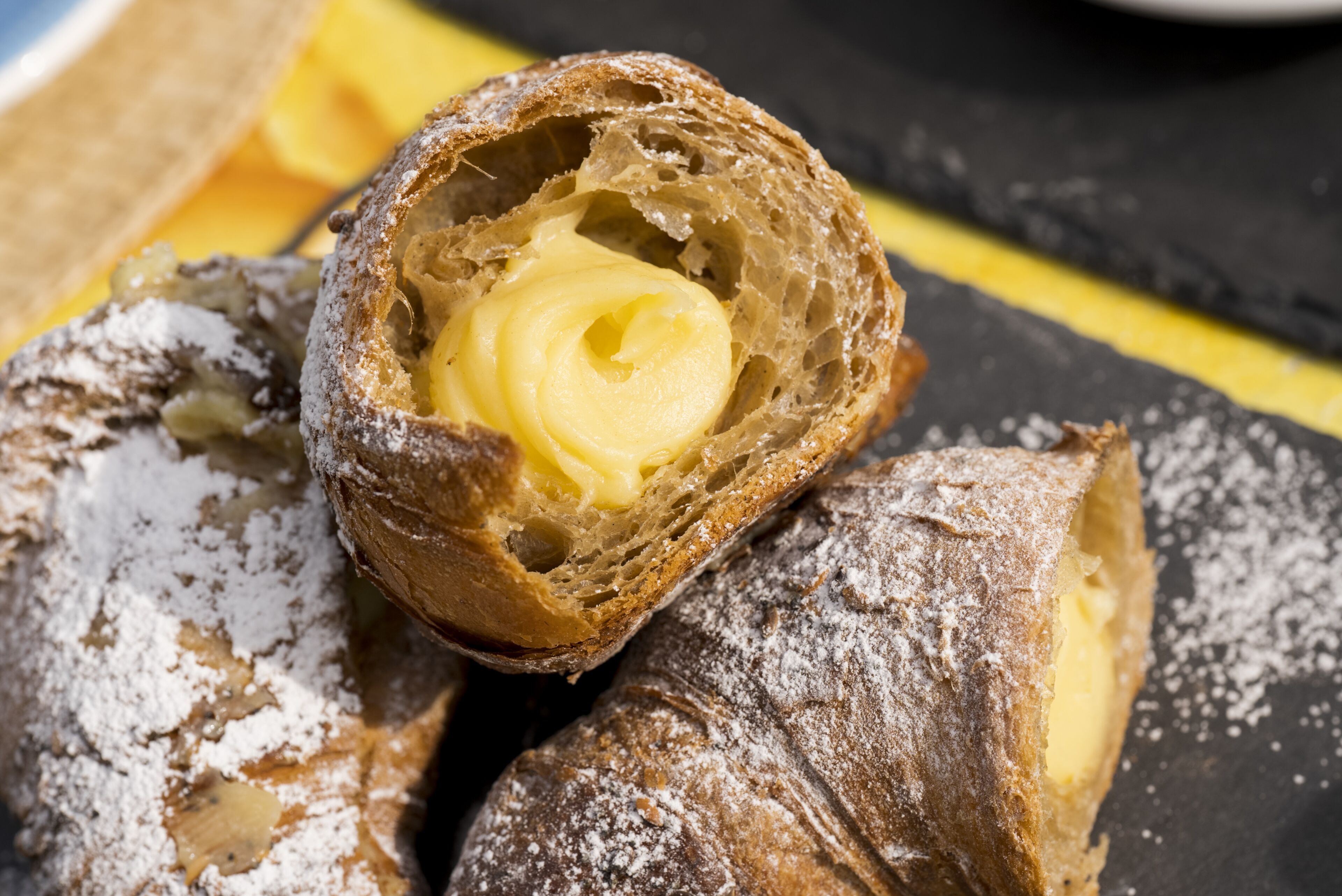 Primer plano de un pastel con relleno cremoso, espolvoreado con azúcar glas.