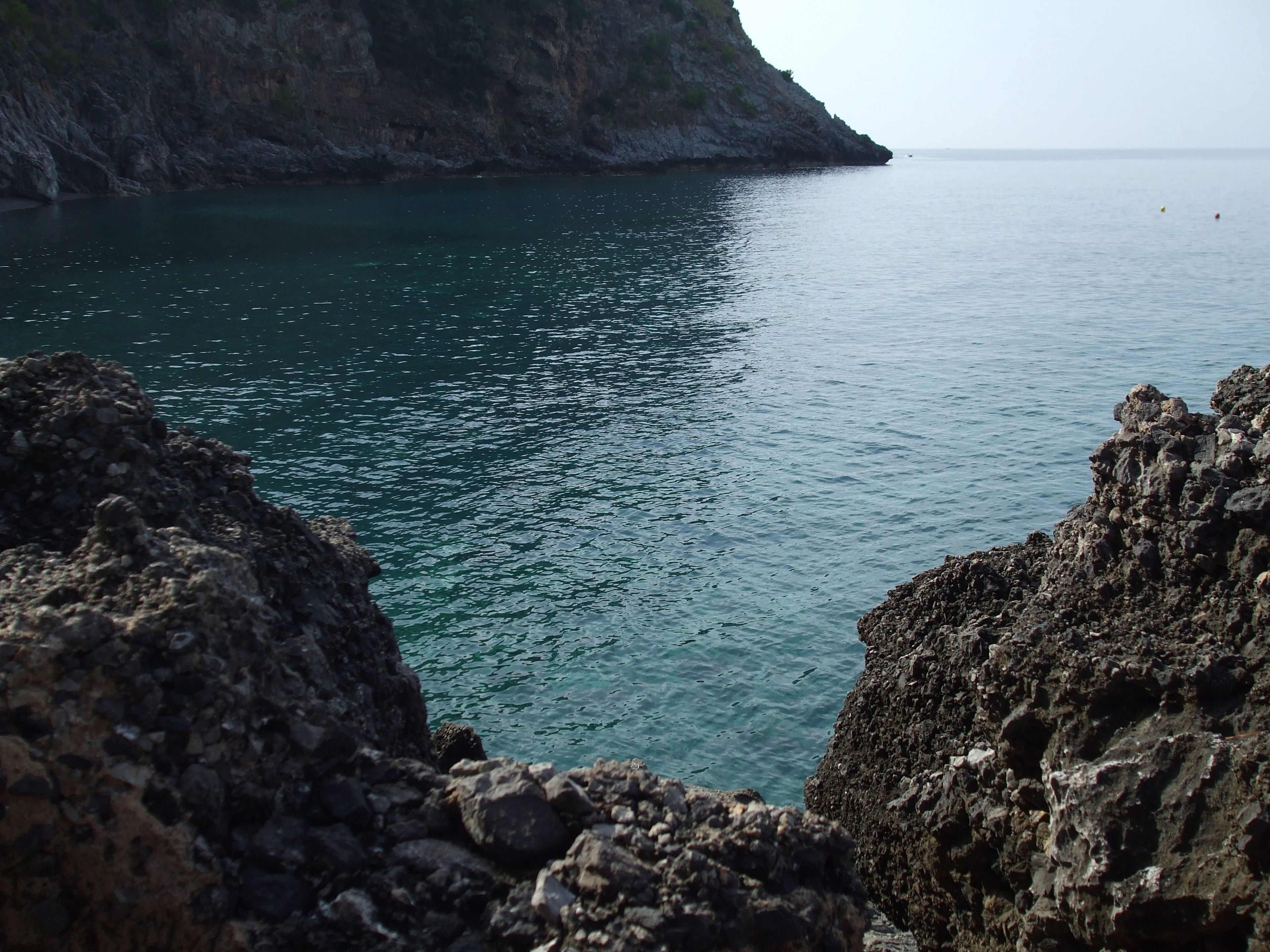 A coastal landscape with rocky terrain and calm sea.