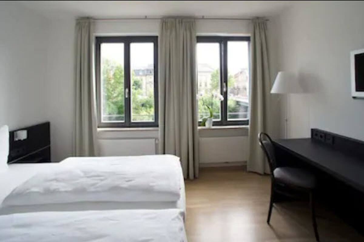 Ein Hotelzimmer mit einem Bett, einem Schreibtisch und einem Fernseher.