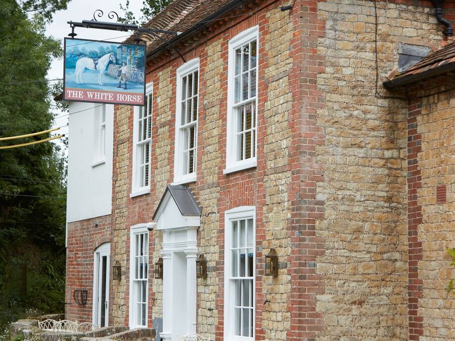 A traditional brick building with a sign reading "The White Horse."