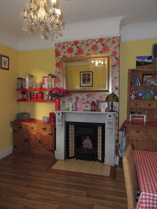 A cozy living room with a fireplace, wooden furniture, and a bookshelf. - Acara House (Dublin)