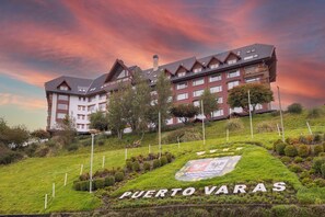 A large hotel with multiple floors and a prominent sign reading 'PUERTO VARAS.' - Wyndham Puerto Varas Pettra (Puerto Varas)