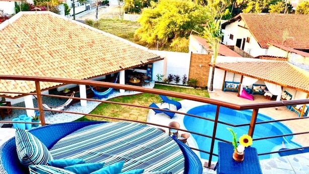 Un espace aménagé au bord de la piscine, avec un hamac, des chaises longues et une petite piscine.