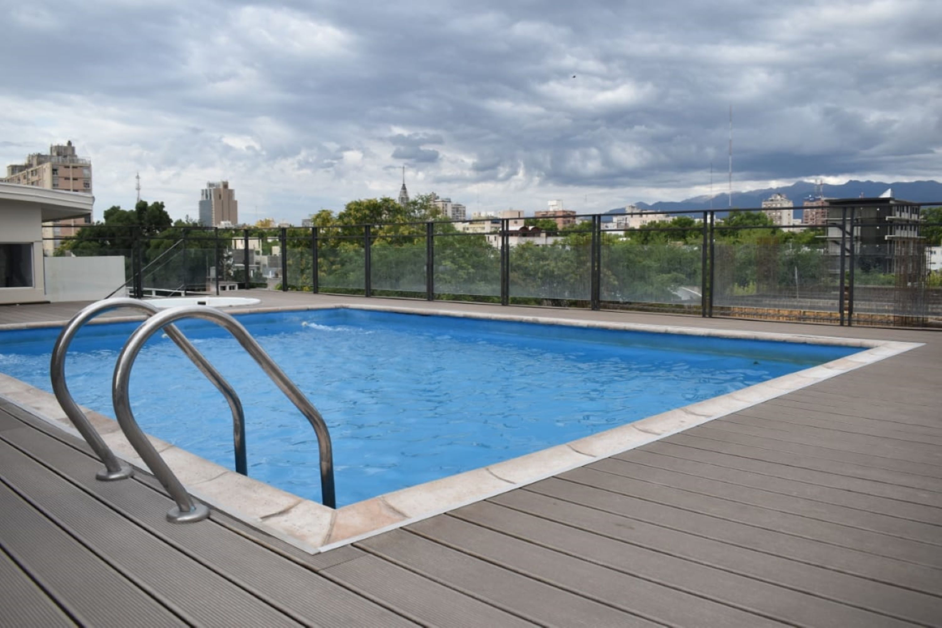 Una piscina al aire libre de temporada, sillones reclinables de piscina