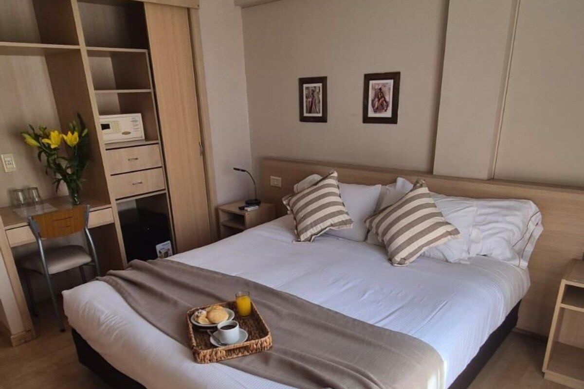Un dormitorio con cama, mesita de noche y armario.