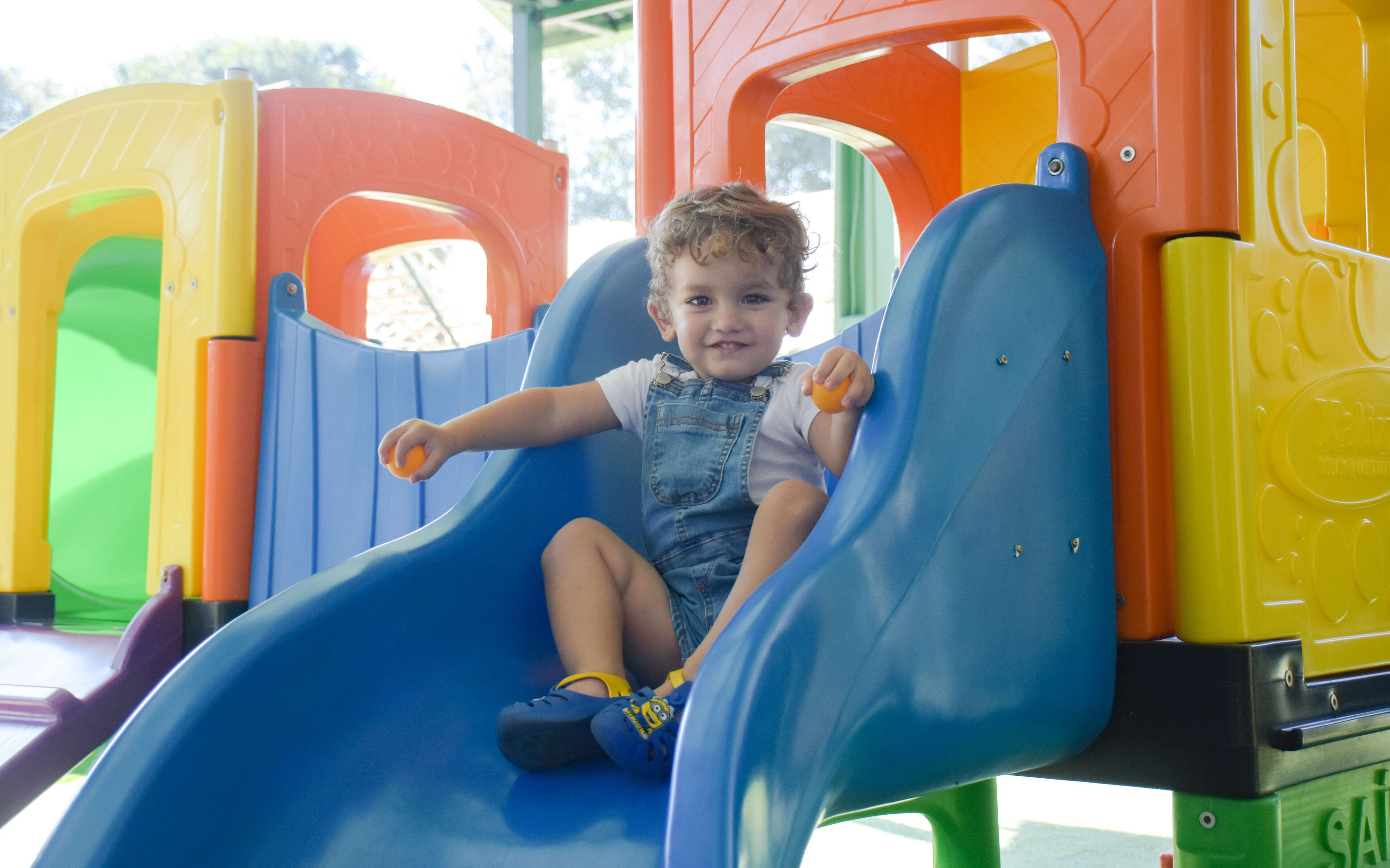 Un enfant sur un toboggan coloré dans un parc.