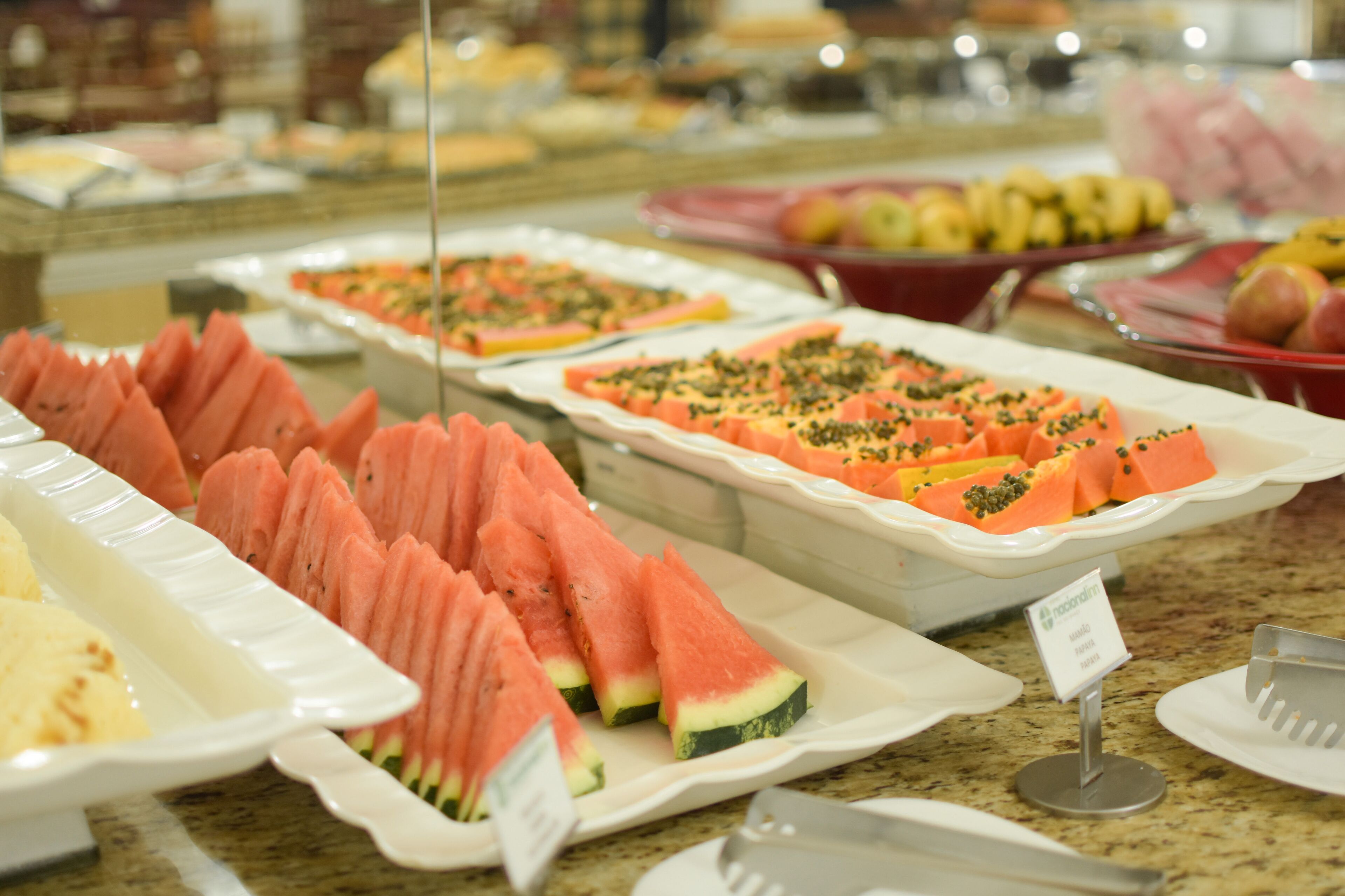A buffet with various food items including watermelon slices and other fruits.