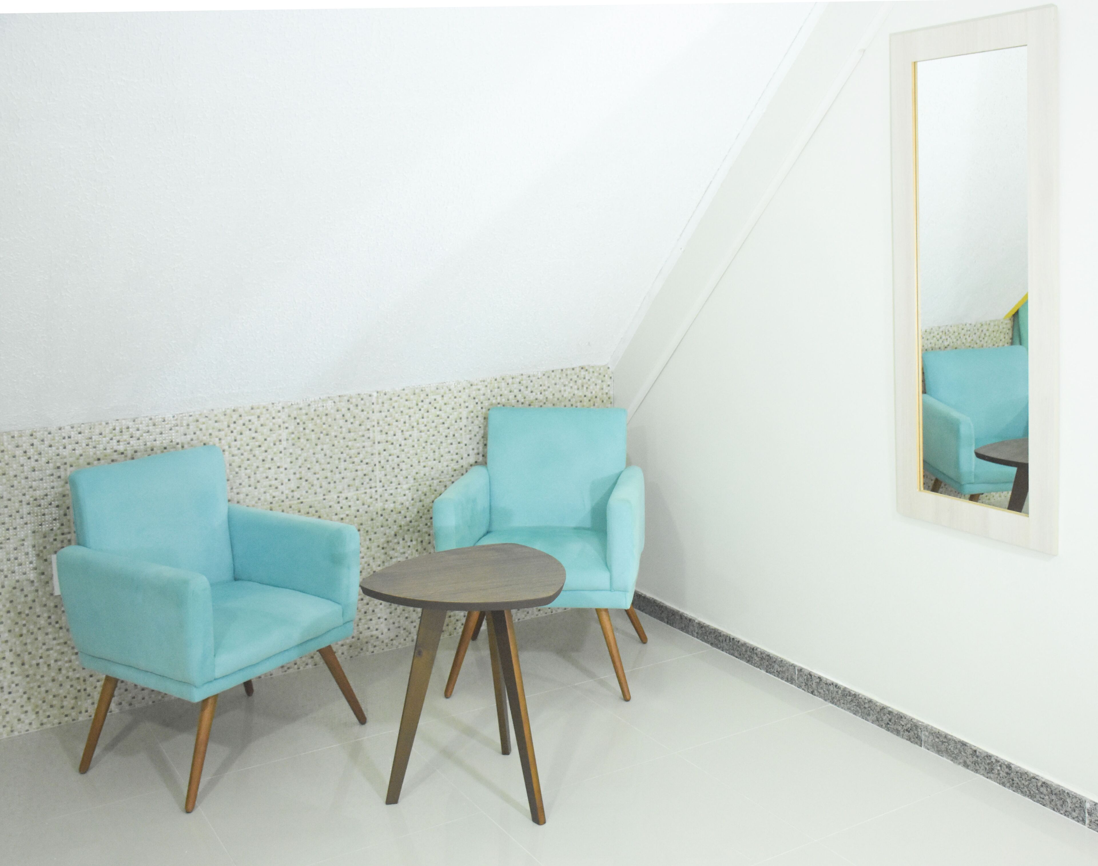 A room with two light blue armchairs and a small round table.