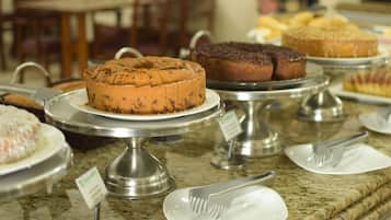 A buffet with various cakes and pastries on display.