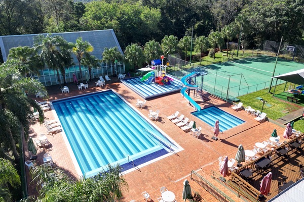 Alberca techada, alberca al aire libre y sombrillas en la alberca