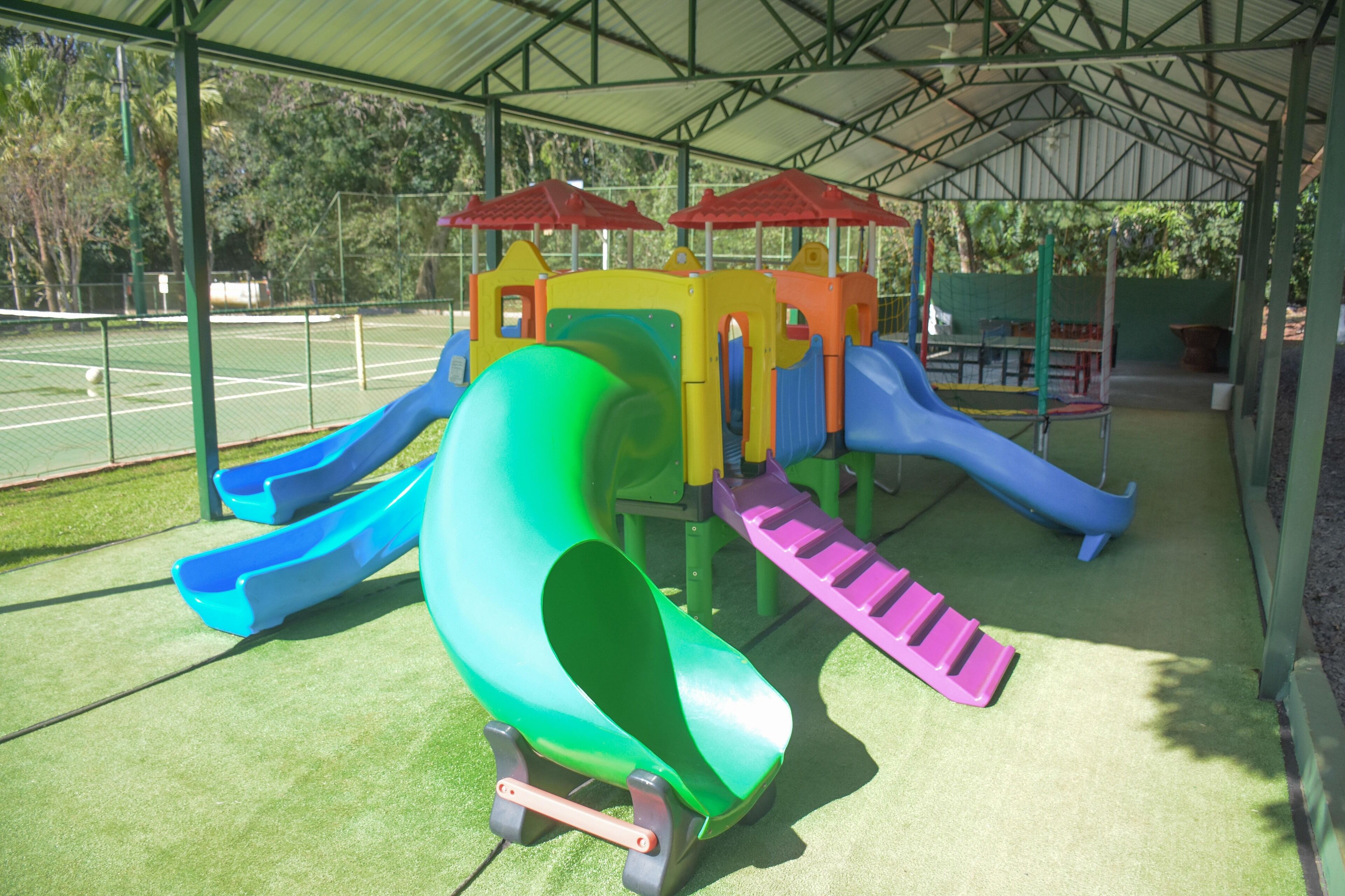 Ein Spielplatz mit mehreren Rutschen und einem überdachten Bereich.