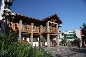 A hotel with a stone facade, wooden balcony, and potted plants. - Hotel Boutique Vendimia Premium (Santa Cruz)