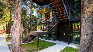 A modern building with a glass facade, a wooden staircase, and a stone pathway.