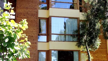 Stunning cabin with a central entrance, flanked by windows, and a balcony above.