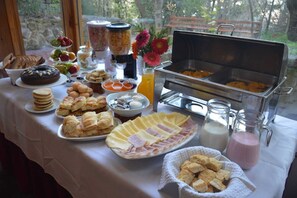 A buffet table with various food items, including pastries, fruits, and a buffet station with hot dishes.