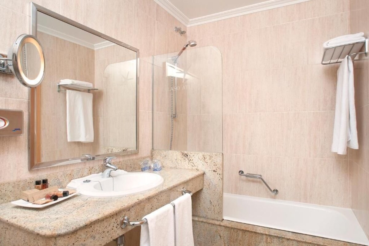 Baño con lavabo, espejo, ducha y bañera.