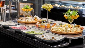 Ein Buffet mit verschiedenen Speisen, darunter Käse, Obst und Gemüse.