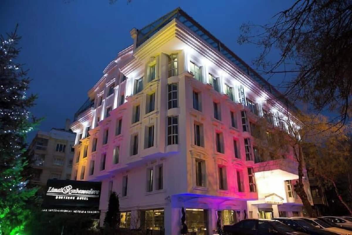 A multi-story hotel with illuminated windows and a signboard.