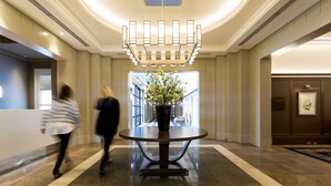 A lobby with a round table, a chandelier, and a vase with flowers. - Yering Gorge Cottages (Yering)