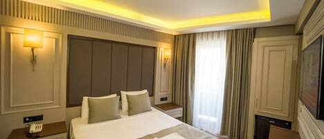 A hotel room with a large bed, bedside lamps, a TV, and a minibar.