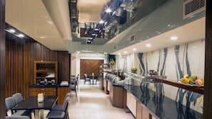 A modern dining area with a buffet, a wooden panel wall, and a marble backsplash. - Martinenz Hotel (Istanbul)