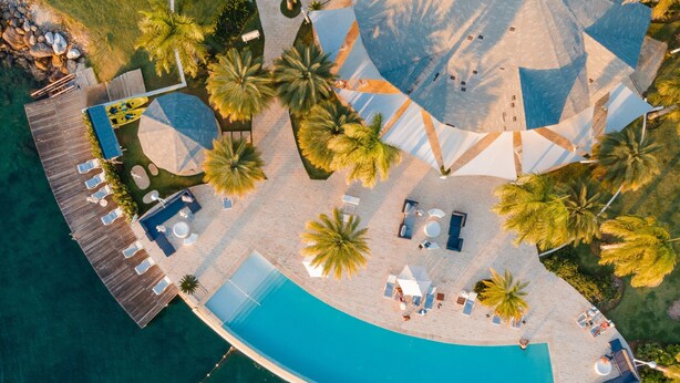 An aerial view of a resort with a large pool, sun loungers, and palm trees. -  Bannister Hotel &  Yacht Club (Samaná)